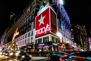 Macy's storefront with illuminated sign at night.