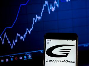 G-III Apparel Group logo on smartphone stock chart background