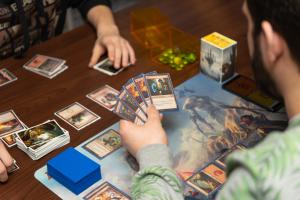 People playing Magic the Gathering card game at table with playmate.