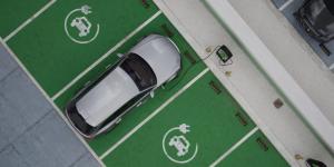 Wide shot of generic EV hybrid vehicle is charging on a station, shopping mall parking