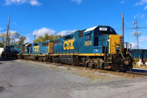 CSX freight train on tracks under blue sky