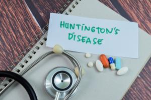 Huntington's Disease write on sticky notes with stethoscope isolated on Wooden Table