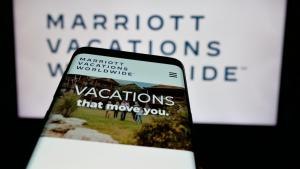 Mobile phone with website of US company Marriott Vacations Worldwide Corporation on screen in front of logo.