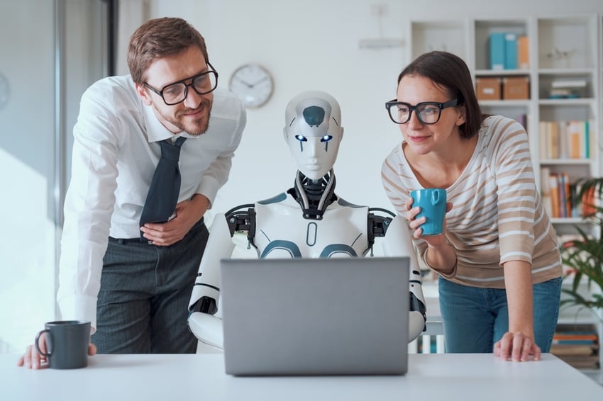 Happy business people supervising an AI robot working in the office