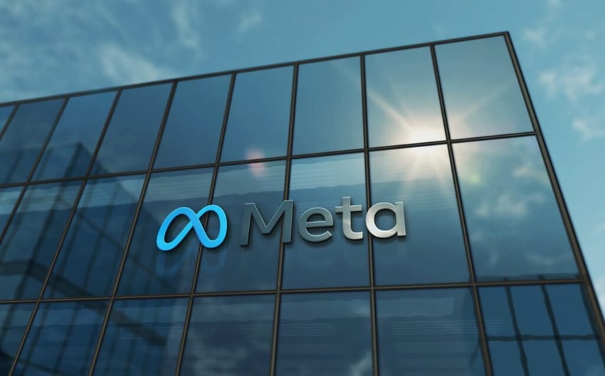 Meta logo on glass building reflecting sky
