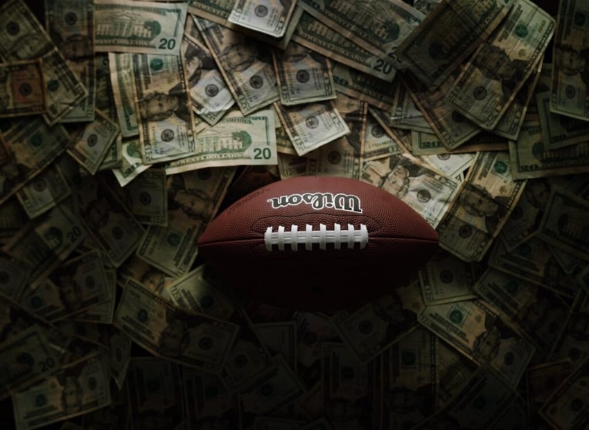 A Wilson football from above on a pile of money