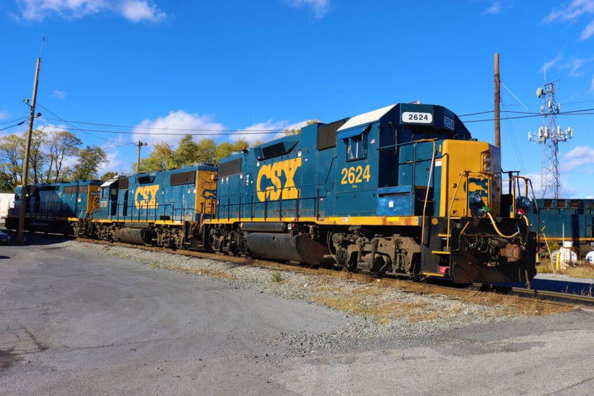 CSX freight train on tracks under blue sky