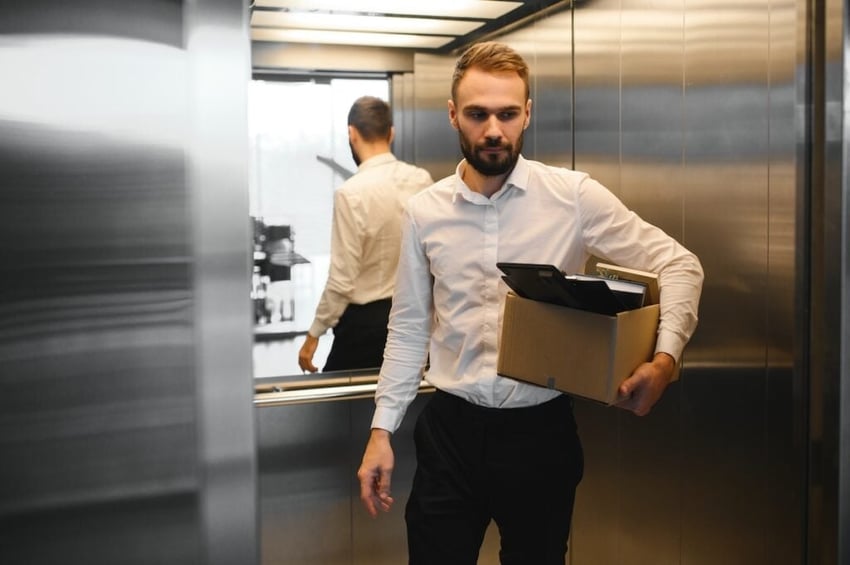 Young handsome businessman in light modern office with carton box