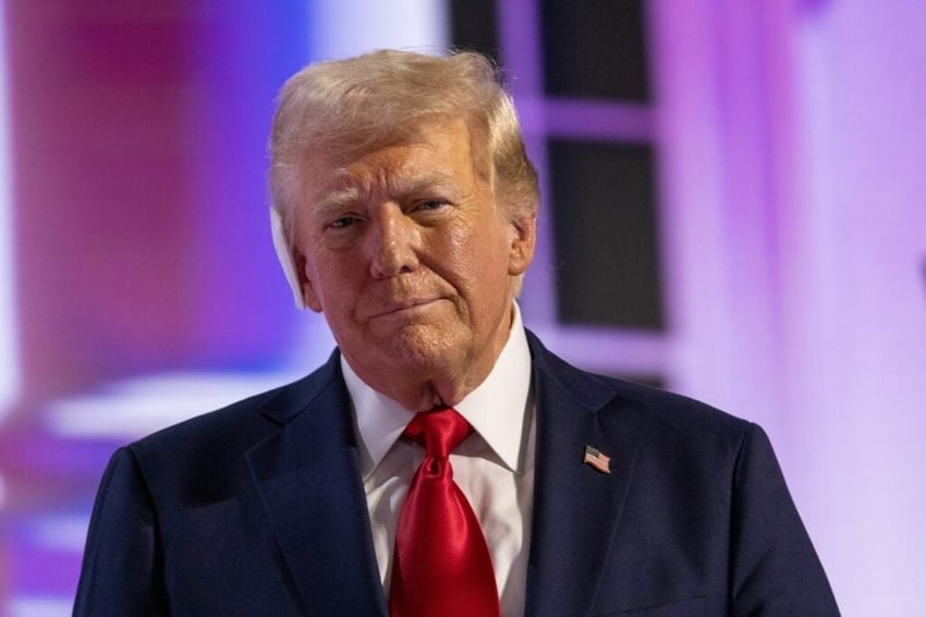 Donald Trump in a suite with red tie.